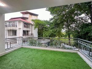 a balcony with green grass in front of a building at NIVANTA-CREAZE by Bendre's in Kārli