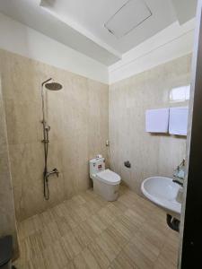 a bathroom with a shower and a toilet and a sink at Lê Gia HOUSE KG in Kiên Lương
