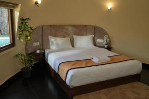 a bedroom with a large bed with white sheets at Lake Lagoon Moonhills in Mennānyam