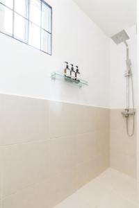 a bathroom with a shower with three bottles on a shelf at Bijunas Homestay in General Luna
