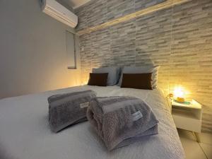 a bedroom with a bed with pillows and a brick wall at Encantos no Porto da Barra in Salvador