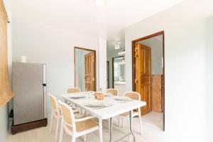 a white dining room with a white table and chairs at Bijunas Homestay in General Luna