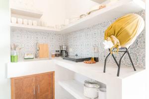 a kitchen with a yellow chair sitting on a counter at Bijunas Homestay in General Luna +7 photos