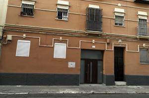 a brown building with windows and a door at Villa Abril en el Porvenir in Seville