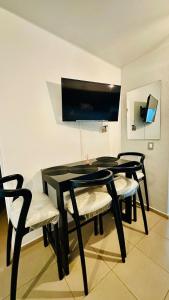 a black dining room table with four chairs and a tv at Casa de Sasha in El Matazano +2 photos
