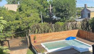 a swimming pool with a blue umbrella next to a fence at V&V House in Concordia