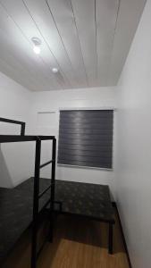 a room with a window with a bed in it at The Cozy Nook - Dorm in Batangas City