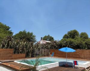 a swimming pool with an umbrella next to a fence at V&V House in Concordia