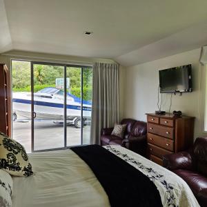 a bedroom with a bed and a sliding glass door at Seventy-Four on Ramsay in Taupo