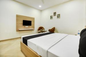 a bedroom with a bed and a flat screen tv at Heritage Villa in Ludhiana