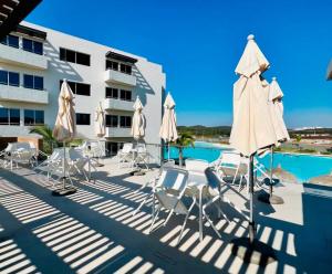 a pool with chairs and umbrellas next to a building at Bluu lagoons in Los Cerritos