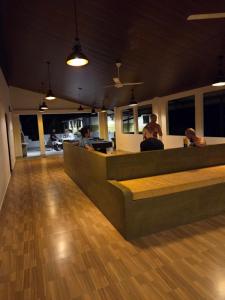 a restaurant with people sitting at a counter at Ceylon Lodge - Airport Transit Hostel in Negombo