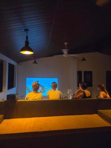 a group of people watching a presentation on a screen at Ceylon Lodge - Airport Transit Hostel in Negombo