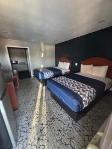 two large beds in a hotel room with at Economy Inn in Ada