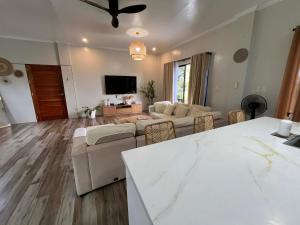 a living room with a couch and a tv at Sondela Cabin Lambug 3BR exclusive Villa in Badian