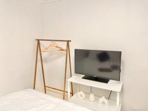 a bedroom with a television on a white shelf at Finetree House in Samgong
