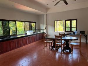 a kitchen with a table and chairs and windows at theorenda 002 in Koh Samui