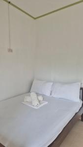 a bed with white sheets and pillows on it at M Residence Capsule Rooms in San Francisco