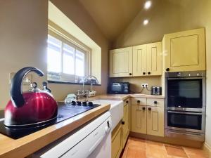 a kitchen with a red tea kettle on the counter at Oaklands Farm - Cottage 5 in Broughton
