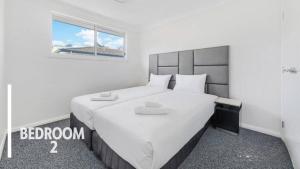 a bedroom with a large white bed with a window at Little Gem in Northwest! in Riverstone