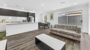 a living room with a couch and a kitchen at Little Gem in Northwest! in Riverstone