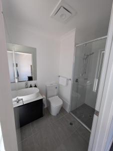 a bathroom with a sink and a toilet and a shower at Little Gem in Northwest! in Riverstone