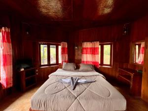 a large bed in a room with windows at บ้านชนเผ่าแคมปิ้งแอนด์รีสอร์ท in Pang Mapha