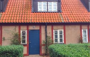 a house with an orange roof and a blue door at 3 Bedroom Beautiful Home In Simrishamn in Simrishamn +9 photos