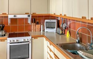 a kitchen with a sink and a microwave at 3 Bedroom Beautiful Home In Simrishamn in Simrishamn