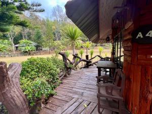 a wooden walkway outside of a house with trees at บ้านชนเผ่าแคมปิ้งแอนด์รีสอร์ท in Pang Mapha