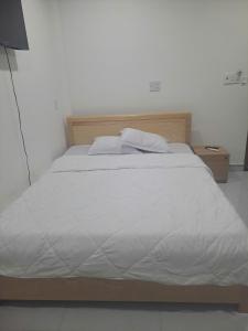 a large white bed with a wooden head board at Hotel Hải Âu in Kỳ Trân (1)