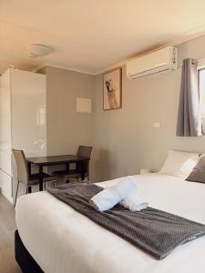 a bedroom with a bed and a table and a desk at Denman Van Village in Denman