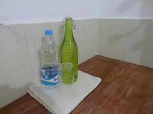 a green bottle and a glass on a towel at Neema Homes in Thekkady