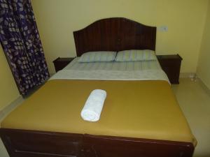 a bed with a white towel laying on it at Neema Homes in Thekkady