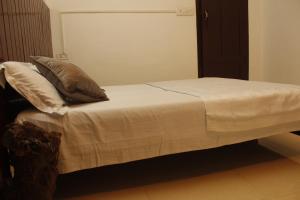 a bed with a pillow on top of it at Neema Homes in Thekkady