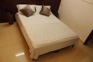 a bed with two pillows on it in a room at Neema Homes in Thekkady