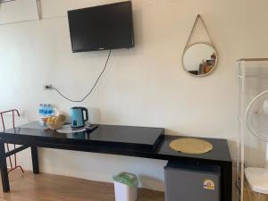 a black desk with a tv on a wall at Chamin Longbeach Bungalow in Ko Lanta