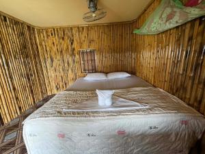 a large bed in a room with a wooden wall at Peace&Love in Ban Sôm