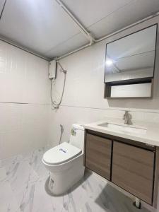a bathroom with a toilet and a sink at Chamin Longbeach Bungalow in Ko Lanta