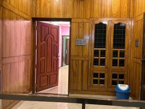a pair of wooden doors in a room at SBJ Road House in Varkala