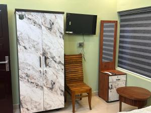 a bedroom with a marble door with a chair and a table at SBJ Road House in Varkala