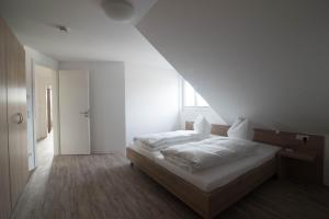 a white bedroom with a bed and a window at BoardingHouse N22 Oberboihingen in Oberboihingen