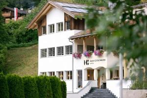 a white building with flowers in the window at Hotel Appartement Haus Gitschberg in Vandoies