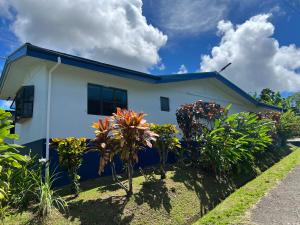 a white house with plants in front of it at Muaitale House in Suva