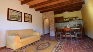 salon z kanapą i jadalnią w obiekcie Fattoria di Fugnano w mieście San Gimignano