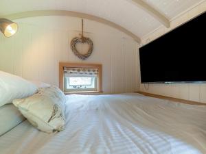 a bedroom with a large bed with a heart hanging on the wall at Herbie's Shepherd Hut - Uk50229 in Nottingham +25 photos