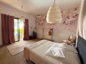 a bedroom with a white bed and a large window at Villa Prana in La Saline les Bains