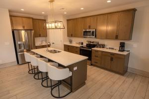 a kitchen with wooden cabinets and a island with bar stools at The Mustang Collection 49 in Page