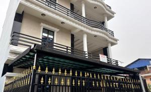 a large house with a black fence with gold gates at The Staycation Pokhara in Pokhara