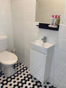 a white bathroom with a toilet and a sink at The Elephants Nest in Victor Harbor +4 photos
